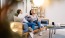 a person sitting on a couch with another woman sitting on the couch